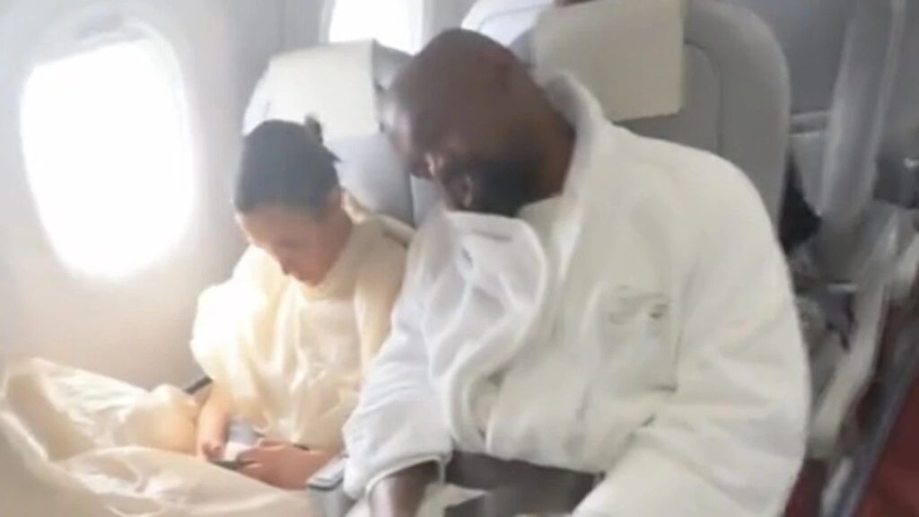 Kanye West spotted flying Economy with wife